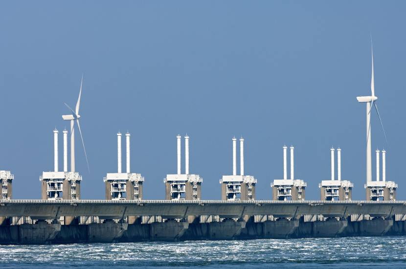 Afbeelding van windmolens en een waterkering